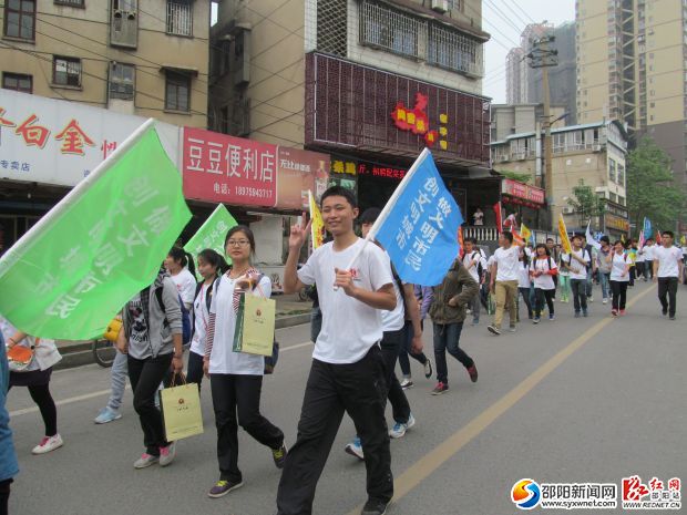 志愿者舉著宣傳創(chuàng)建文明城市的旗幟在行走