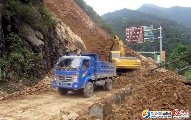 挖機正在清理山體滑坡路段。