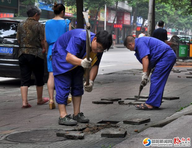 工人正在將破損的彩色道板挖出