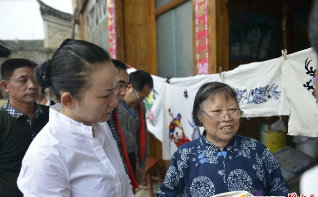 李暉遺址在綏寧縣大園古村與苗族插繡傳承人陽(yáng)利春交談