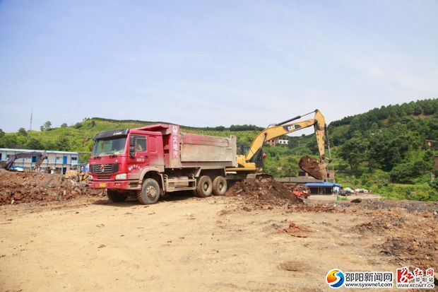 挖土機(jī)將挖出的泥土運(yùn)進(jìn)渣土車。