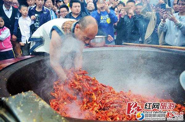 “鬼谷神功”大師唐程剛將手伸進油鍋，翻炒龍蝦。