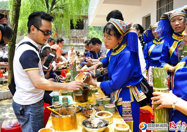 長龍宴上瑤族姑娘身著瑤服給遠(yuǎn)道而來的客人敬酒、敬茶、獻(xiàn)烏飯