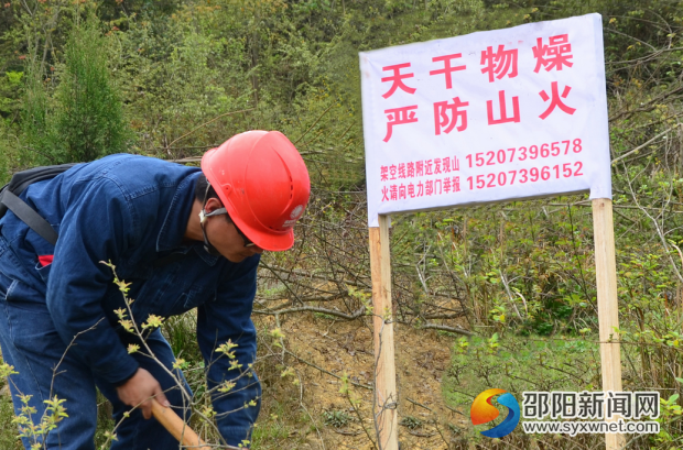 國網(wǎng)邵陽供電公司員工在電力設施保護區(qū)設立防山火警示牌