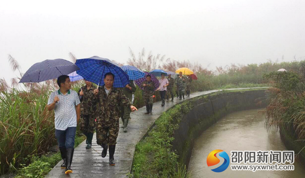 圖為該站共產(chǎn)黨在雨中巡查渠道運行情況