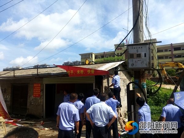 圖為城管執(zhí)法人員協(xié)助拆除校園周邊的臨時過渡棚