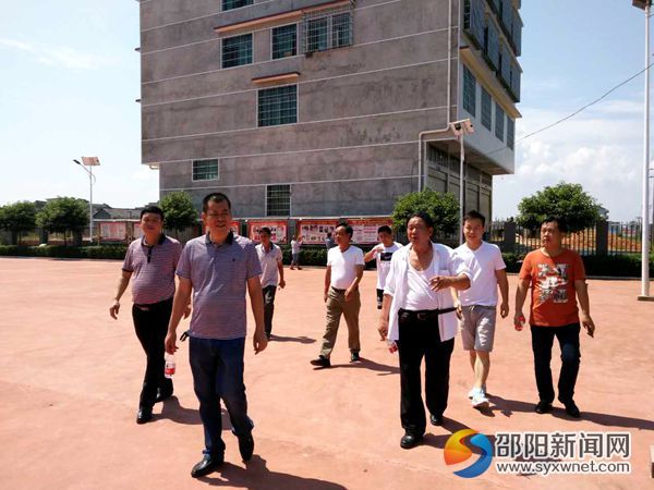 圖為鎮(zhèn)黨委書記寧效龍帶隊參觀云山村黨建宣傳欄