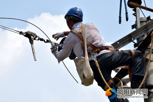 在綏寧縣金屋塘鎮(zhèn)，檢修人員臉龐已被曬得黑里透紅的電力施工人員，在烈日下對(duì)金屋鎮(zhèn)10千伏金張線紅萬(wàn)支線桿上的導(dǎo)線與瓷瓶進(jìn)行更換。 (2)