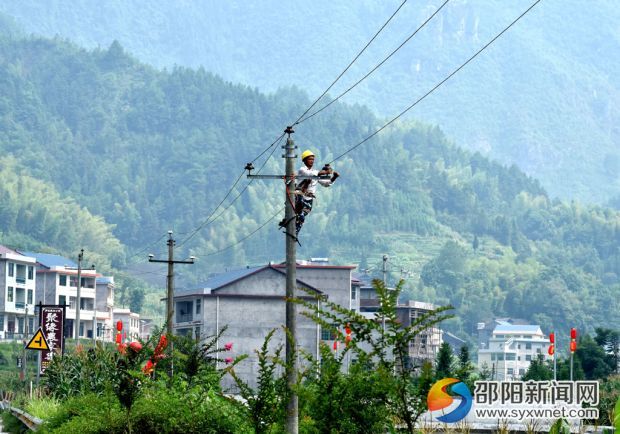 在綏寧縣金屋塘鎮(zhèn)，檢修人員臉龐已被曬得黑里透紅的電力施工人員，在烈日下對金屋鎮(zhèn)10千伏金張線紅萬支線桿上的導(dǎo)線與瓷瓶進(jìn)行更換。 (1)