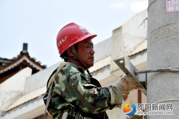 在綏寧縣金屋塘鎮(zhèn)，檢修人員臉龐已被曬得黑里透紅的電力施工人員，在烈日下對(duì)金屋鎮(zhèn)10千伏金張線(xiàn)紅萬(wàn)支線(xiàn)桿上的導(dǎo)線(xiàn)與瓷瓶進(jìn)行更換。 (7)