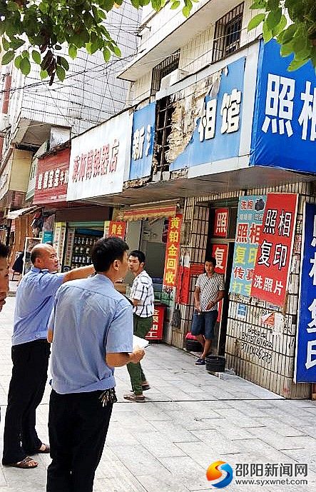 圖為執(zhí)法人員在排查門(mén)店招牌