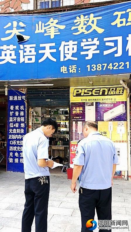 圖為執(zhí)法人員在排查門(mén)店招牌