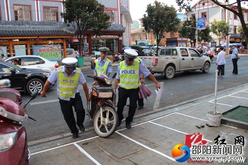 工作人員將亂停放摩托車(chē)擺放到停車(chē)位