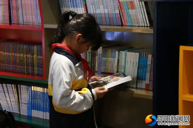 高撑小学校园共享书店内，一名学生正沉浸在知识的海洋里