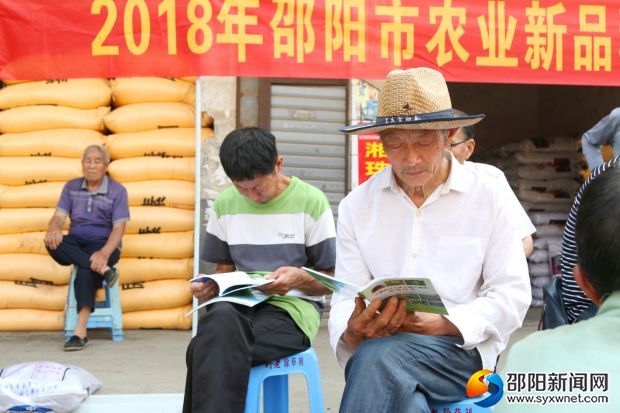 農戶正在認真學習科普資料中關于蔬菜種植的知識