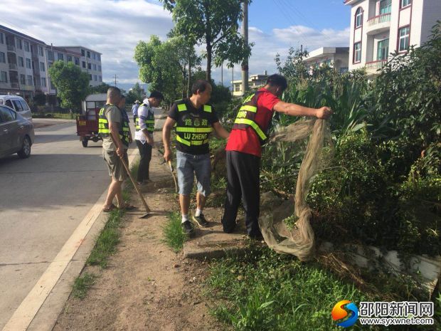 新寧縣路政隊員正在清除路肩農作物