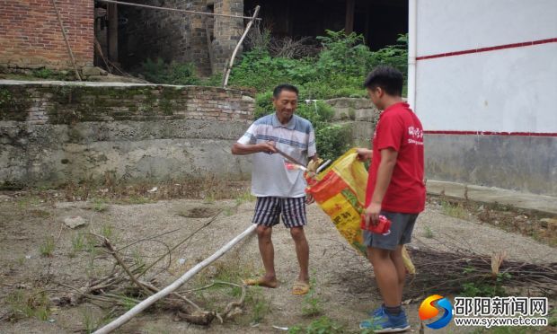 观察团成员帮助刘净城清理村道垃圾