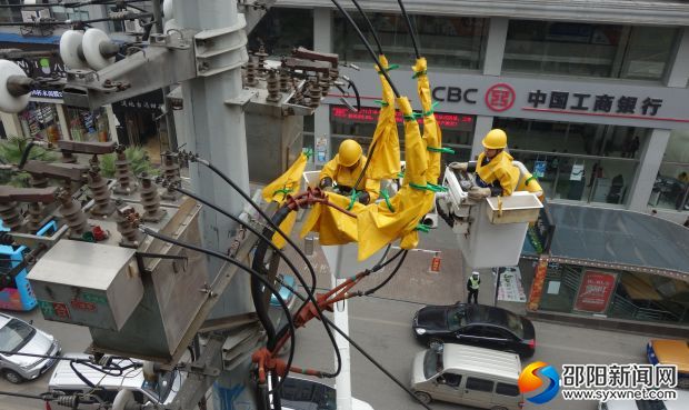 国网邵阳公司员工在红旗路大祥坪体育馆附件带点检修供电设备。