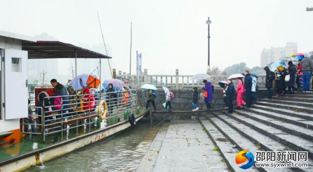 九江碼頭的中小學生排隊依次上船渡過資江，邵陽市地方海事局的工作人員正在現場進行指揮。