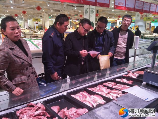 执法人员对超市的猪肉质量安全进行排查