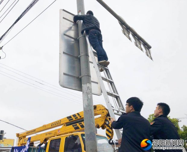 工作人員正在拆除西湖路祭旗坡廣告牌