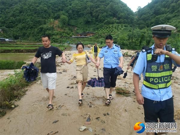 民警正在幫助行人通過漫水道路