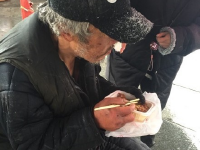 流浪老人北京街頭吃雪 好心路人買飯送衣