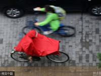 北京迎明顯降雨天氣 民眾帶雨具出行